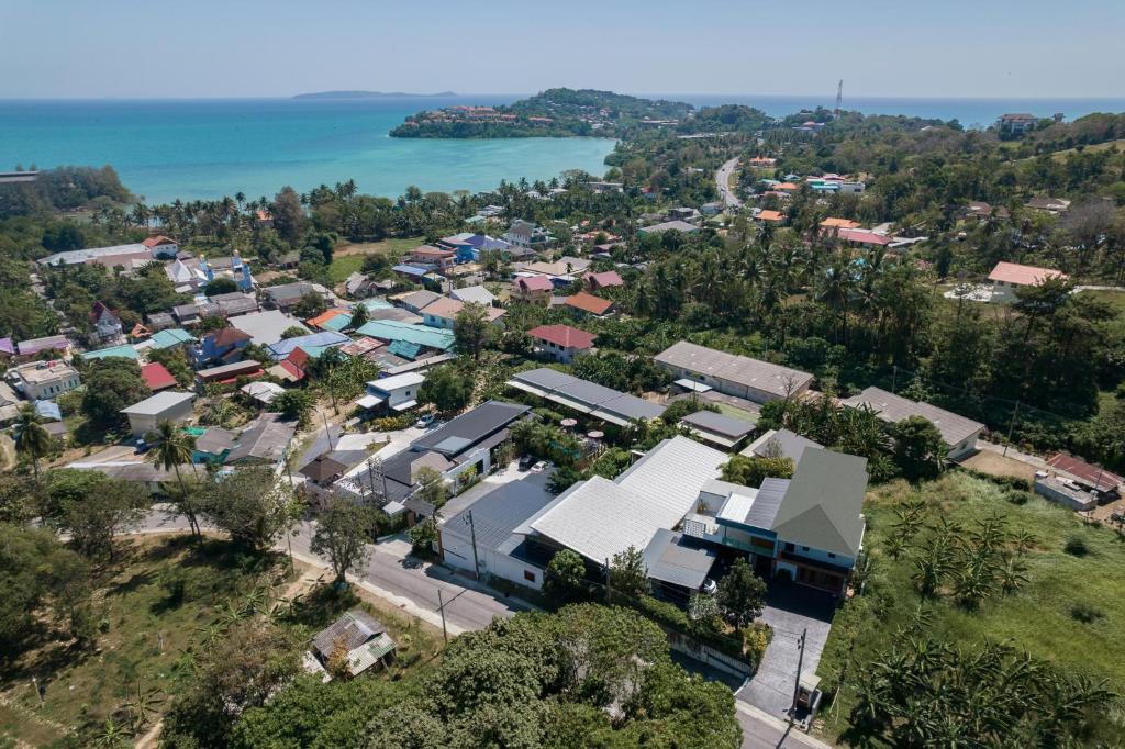 an aerial view of a small town next to the water at The Loft Panwa Resort in Panwa Beach