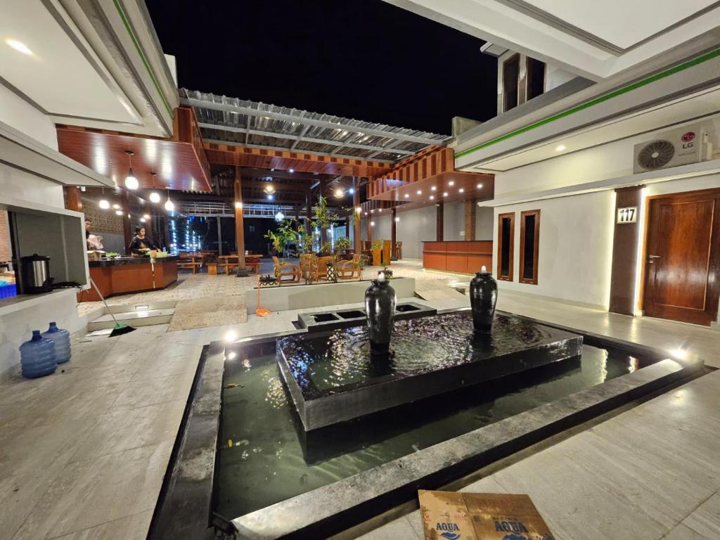 a lobby with a fountain in the middle of a building at Omah Joglo Bugis in Wendit