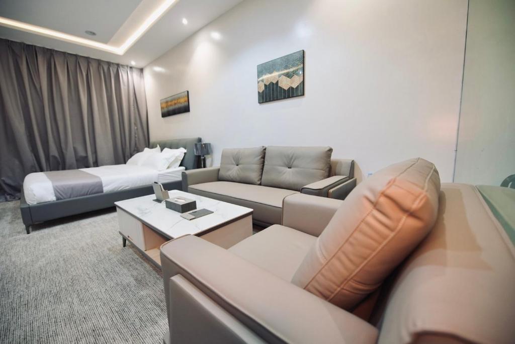 een woonkamer met een bank en een bed bij فندق قمم بارك Qimam Park Hotel 7 in Al Baha