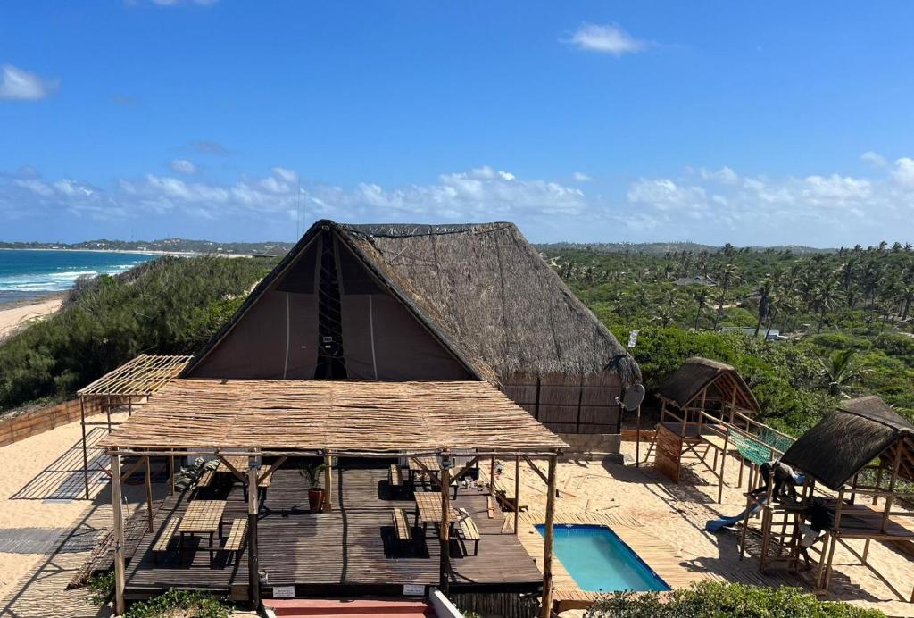 a large tent on a beach with a pool at Mango Beach Resort in Praia do Tofo