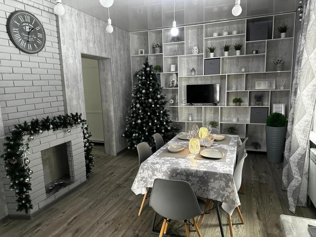 ein Esszimmer mit einem Weihnachtsbaum und einem Kamin in der Unterkunft Paradise in Tastybulak