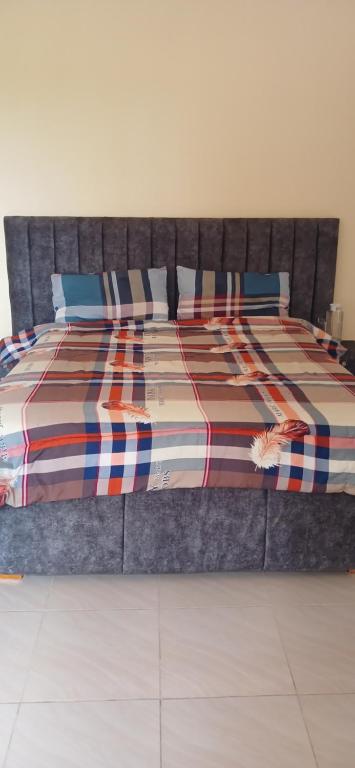 una cama con un edredón colorido y almohadas en ella en M&R Property., en Ukunda