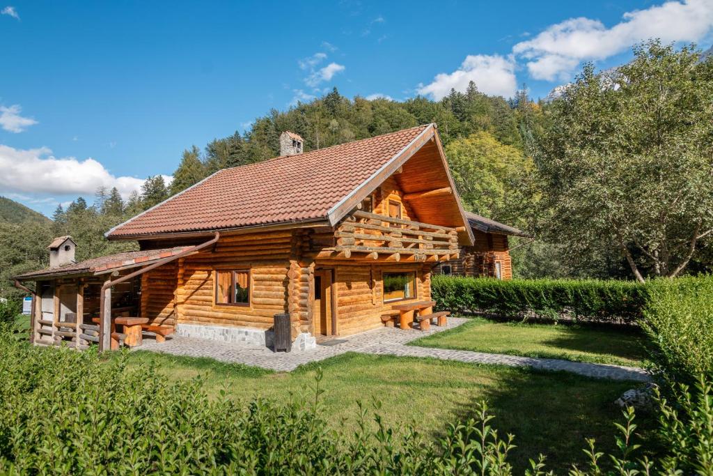 une cabane en rondins dans les bois avec une cour dans l'établissement Resort 7 Crai - Cabana Baciu, à Zărneşti