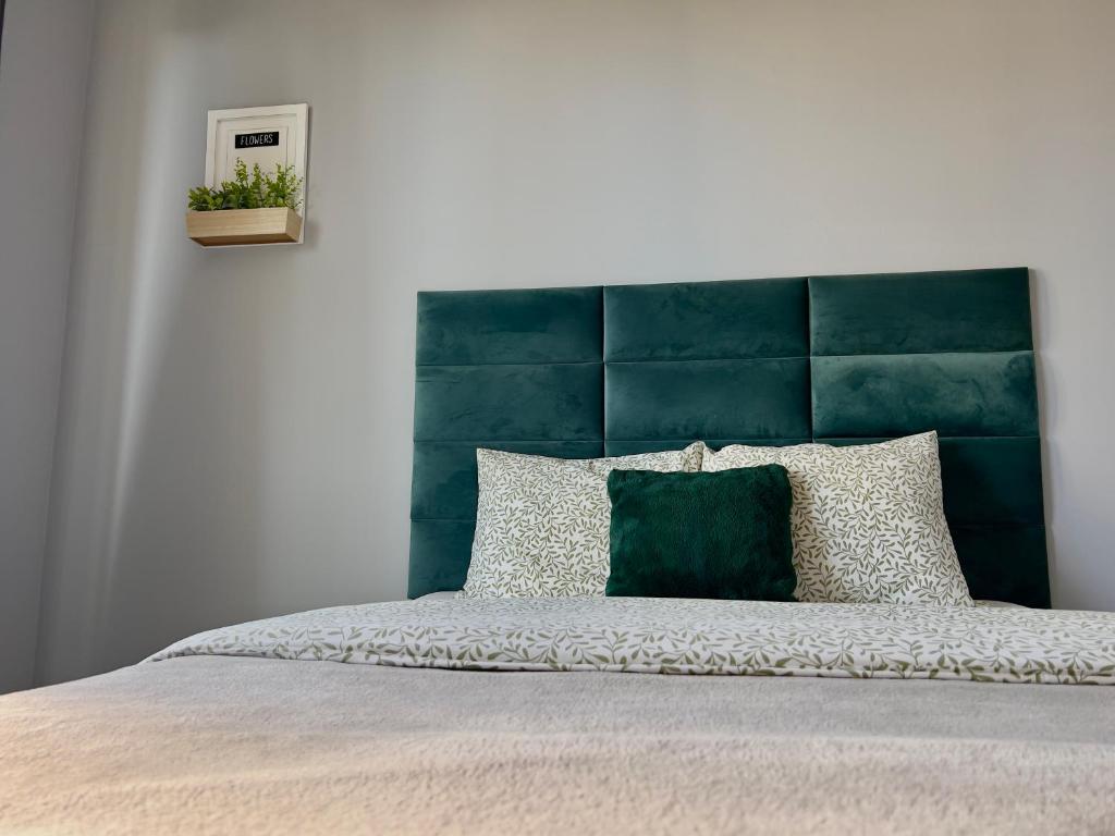 un letto con testiera blu e testiera verde di Parkcity Park Śląski a Katowice