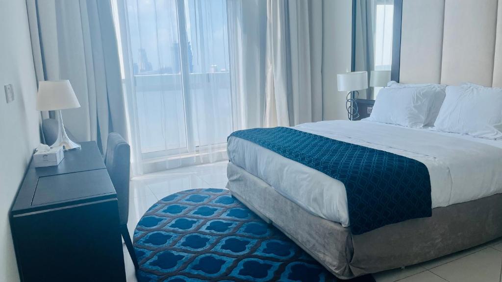 a bedroom with a bed and a large window at Walking distance to dubai mall Full burj Khalifa view and fountain view new year full fireworks view 2BR in Dubai