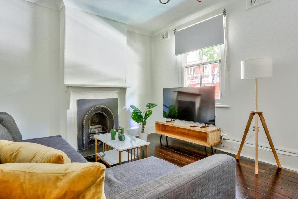 a living room with a couch and a tv at 2 Bedroom House Darling Harbour Kent St in Sydney