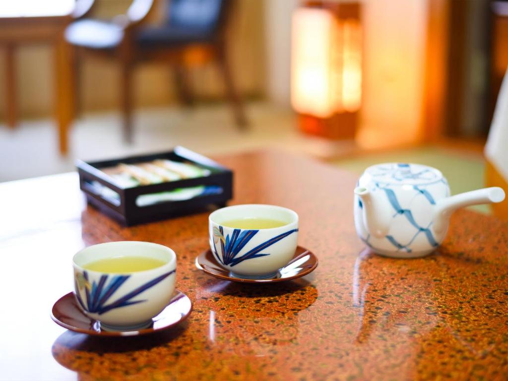 dos tazas de café sentadas en una mesa con un estéreo en Yuzawa New Otani en Yuzawa