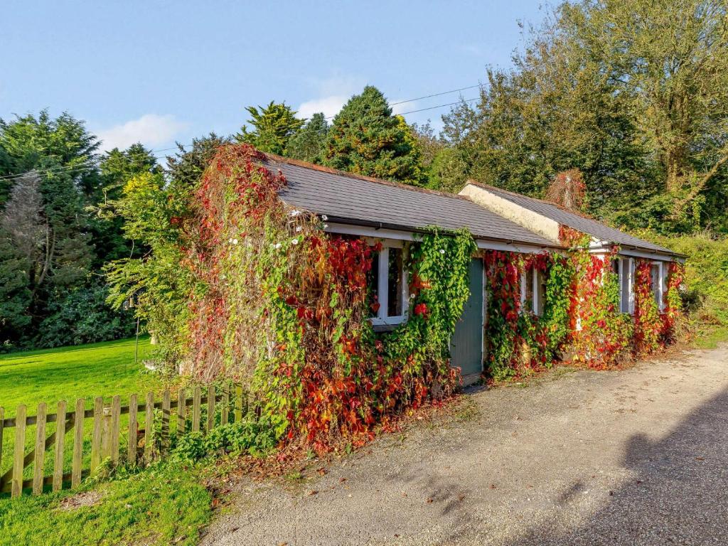 una casa cubierta de hiedra junto a una valla en 1 Bed in Bigbury-on-Sea 05069 en Woodleigh
