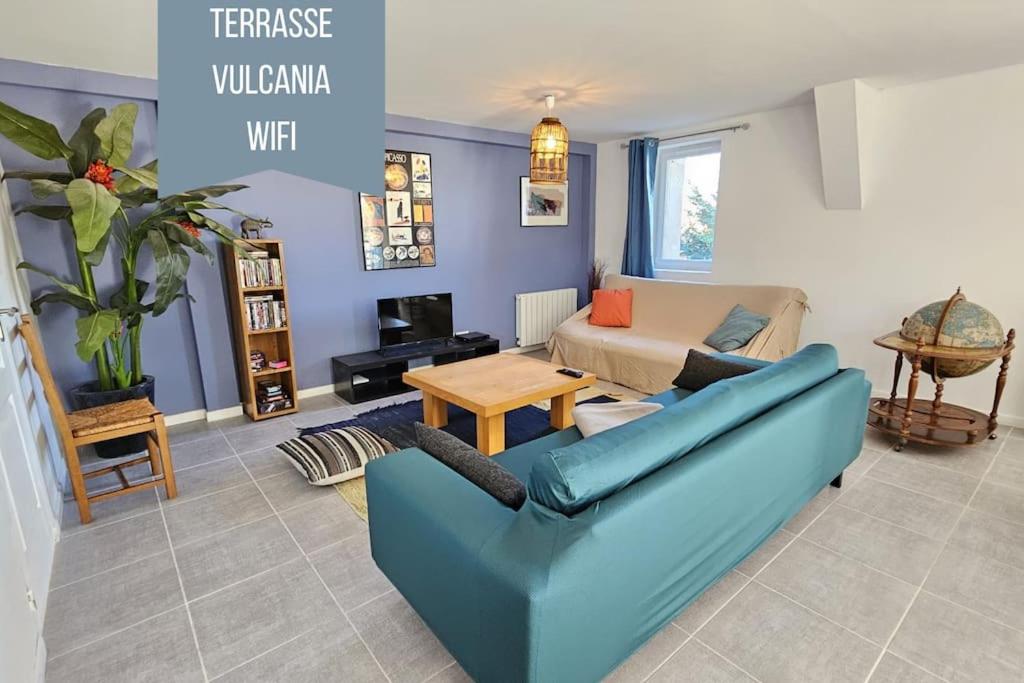 - un salon avec un canapé bleu et une table dans l'établissement La Grande Ourse - Wifi - Terrasse - Vulcania, à Saint-Ours