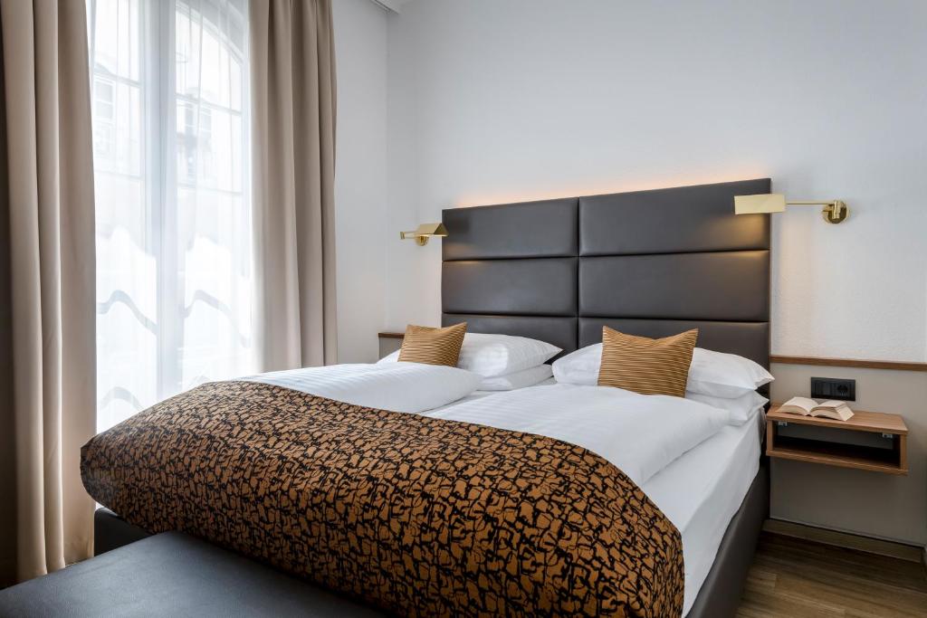 Postel nebo postele na pokoji v ubytování IMLAUER Hotel Nestroy Wien