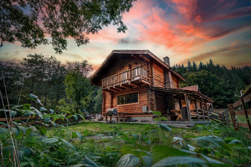 a log cabin in the woods at sunset at Resort 7 Crai - Cabana Calinet in Zărneşti