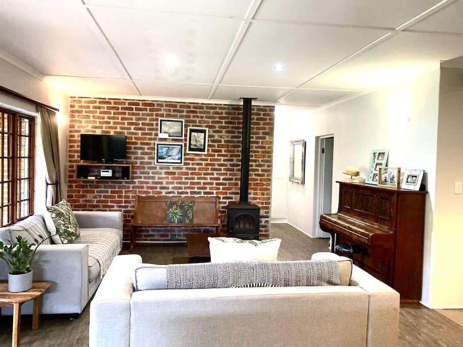 a living room with a couch and a piano at The Croft cottage in Knysna