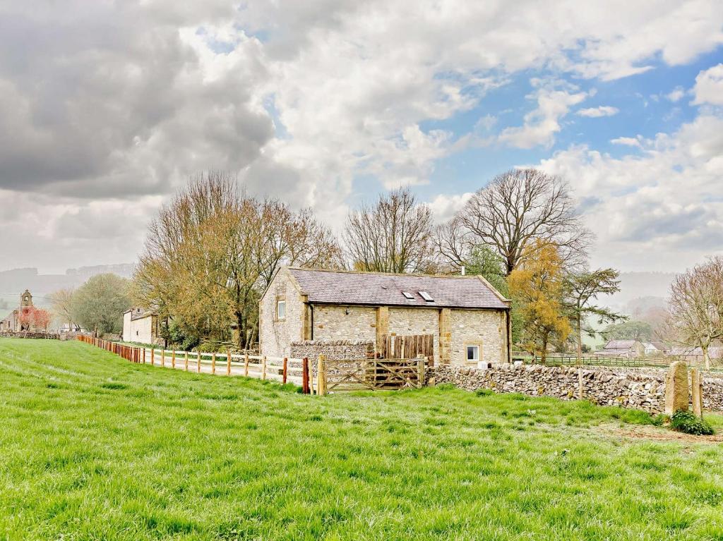 an old stone barn in a field with a fence at 2 Bed in Little Longstone 44607 in Great Longstone