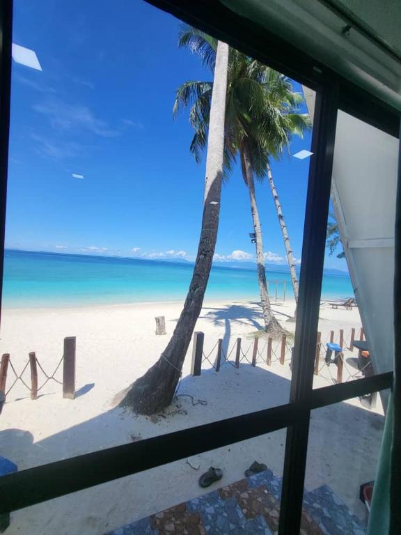 widok na plażę z palmami i ocean w obiekcie DEWATI ROOMSTAY B&B w mieście Pulau Lang Tengah