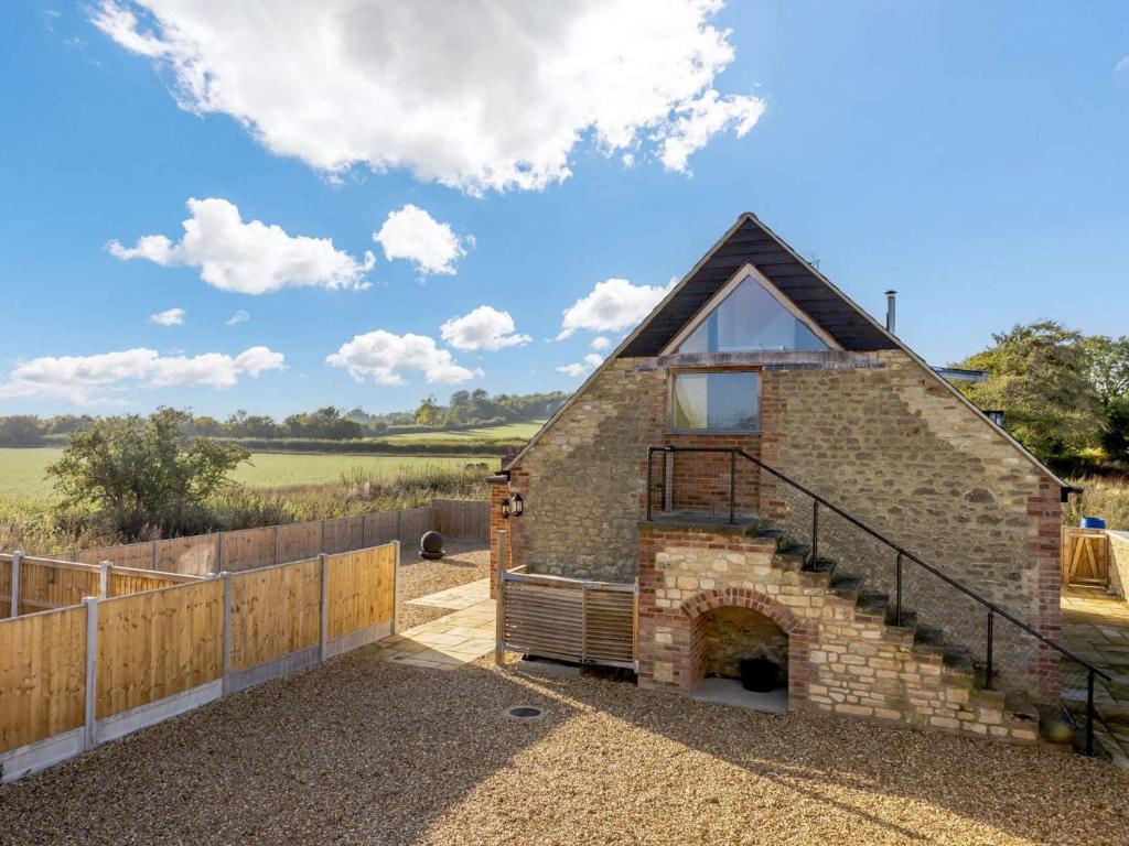 a barn conversion with a brick fireplace and a wooden fence at 1 Bed in Farringdon 88573 in Coxwell