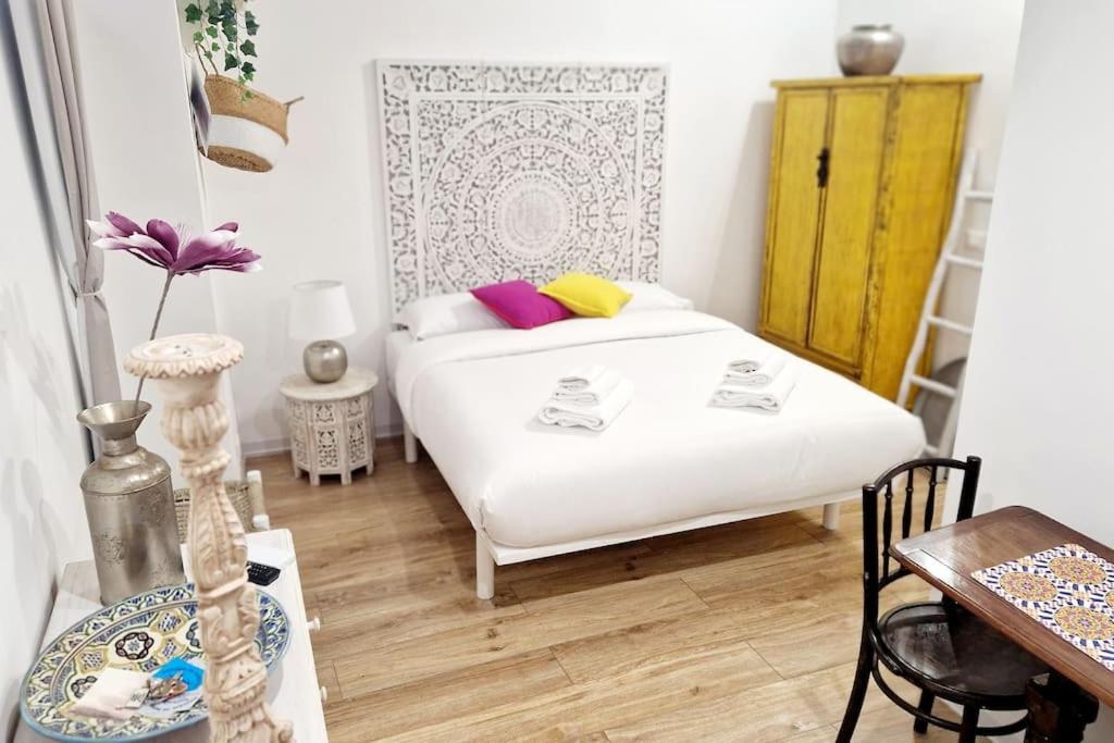 a bedroom with a white bed and a table at Small & cozy near Piazza Navona in Rome