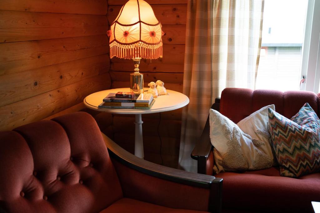 a living room with a table and a chair and a lamp at Åndalsnes Hytteutleie in Åndalsnes