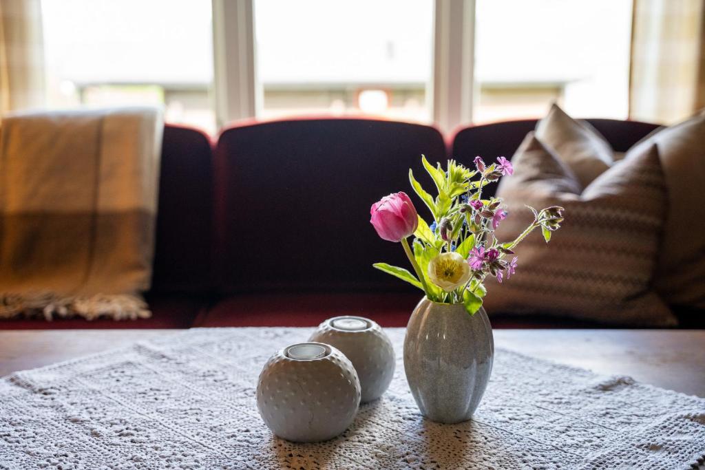 a vase with flowers in it sitting on a table at Åndalsnes Hytteutleie in Åndalsnes