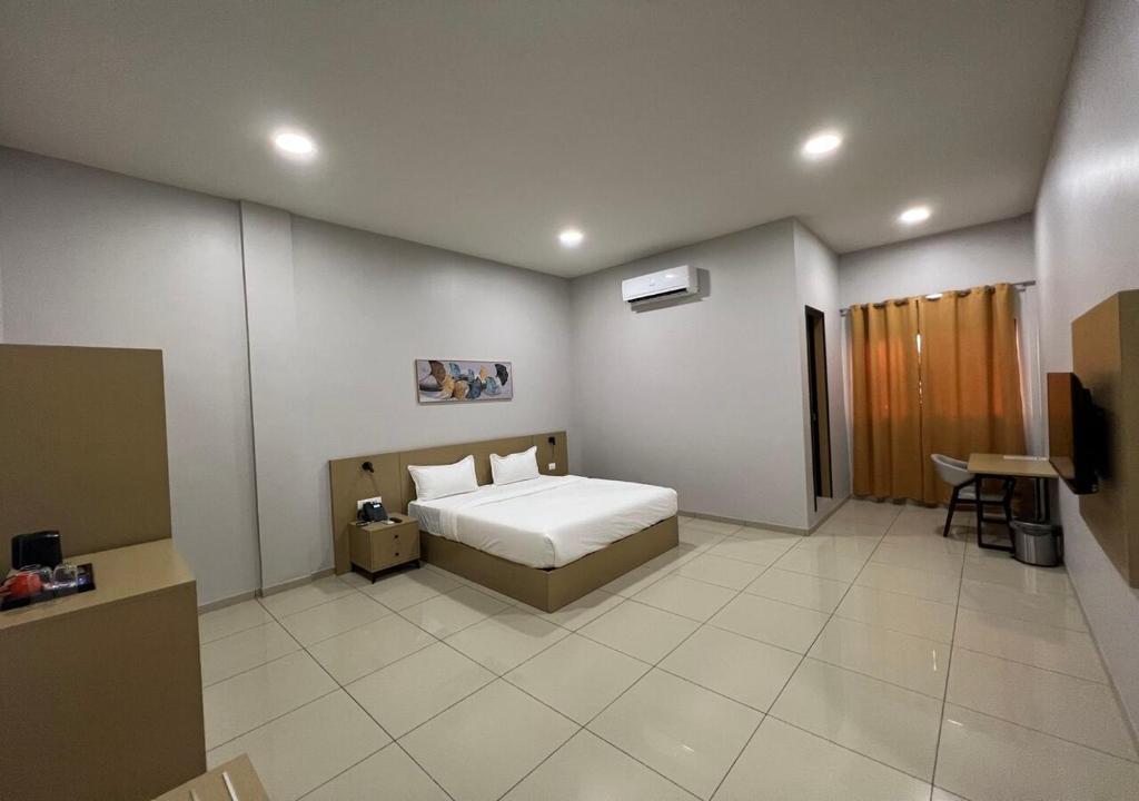 金夏沙的住宿－Ixoras Hotel Victoire，一间卧室配有一张床和一台电视。