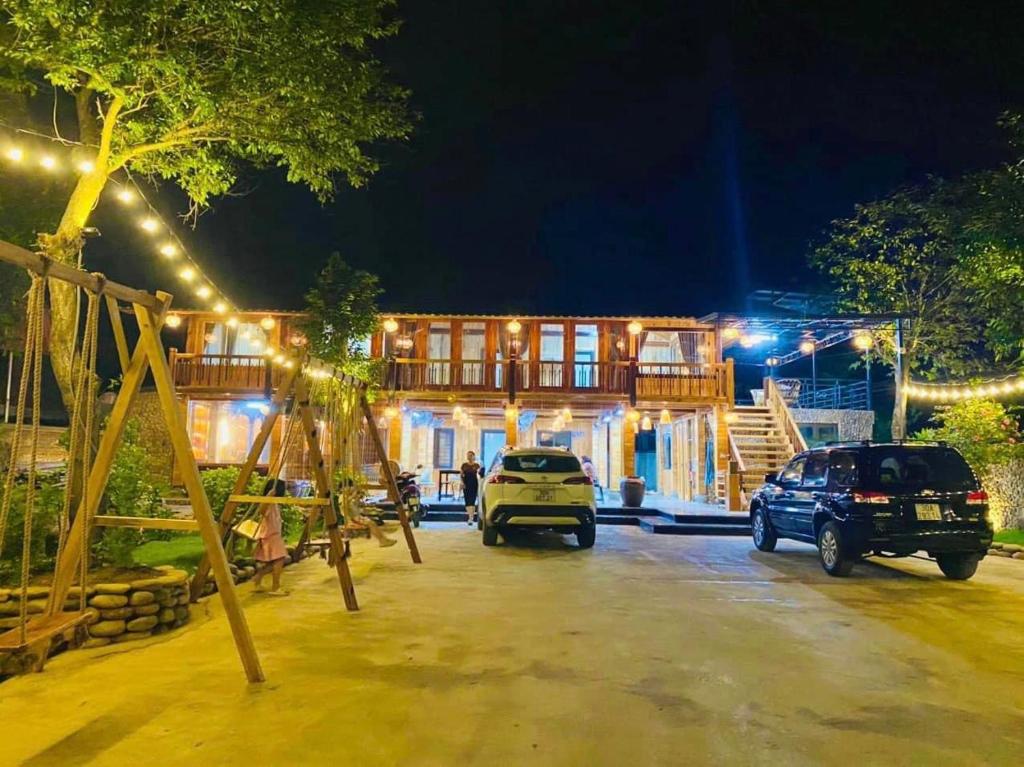 a house with two cars parked in front of it at Nam Nam Homestay in Bản Cong Na