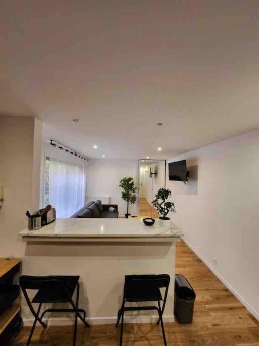 sala de estar con 2 sillas y sofá en Superbe appartement à 8 minutes de la nation., en París