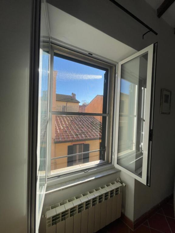 ein Fenster in einem Zimmer mit Blick auf ein Gebäude in der Unterkunft L'Orbetellana - Guest House in Orbetello