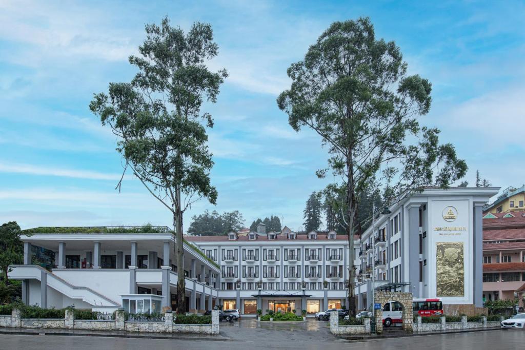a rendering of a hotel with trees in the foreground at Sapa Convention Center (Green Forest Hotel) in Sa Pa