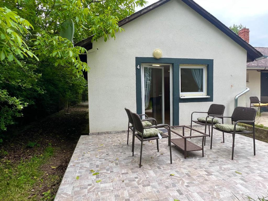 um grupo de cadeiras e uma mesa em frente a uma casa em F4 Mouintain View Corner House with Terasse and Garden em Kőszeg