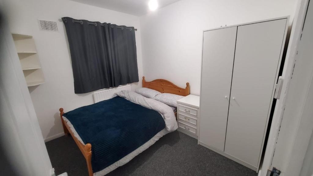 ein kleines Schlafzimmer mit einem Bett und einem Spiegel in der Unterkunft Cosy And Relaxing in Chatham