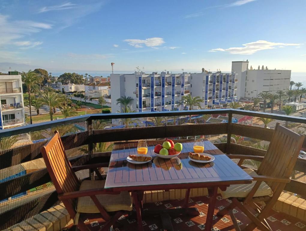 una mesa con comida y bebida en el balcón en Cassinello Roquetas en Roquetas de Mar