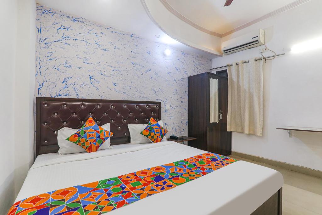 um quarto com uma cama com um edredão colorido em FabExpress Victory em Lucknow