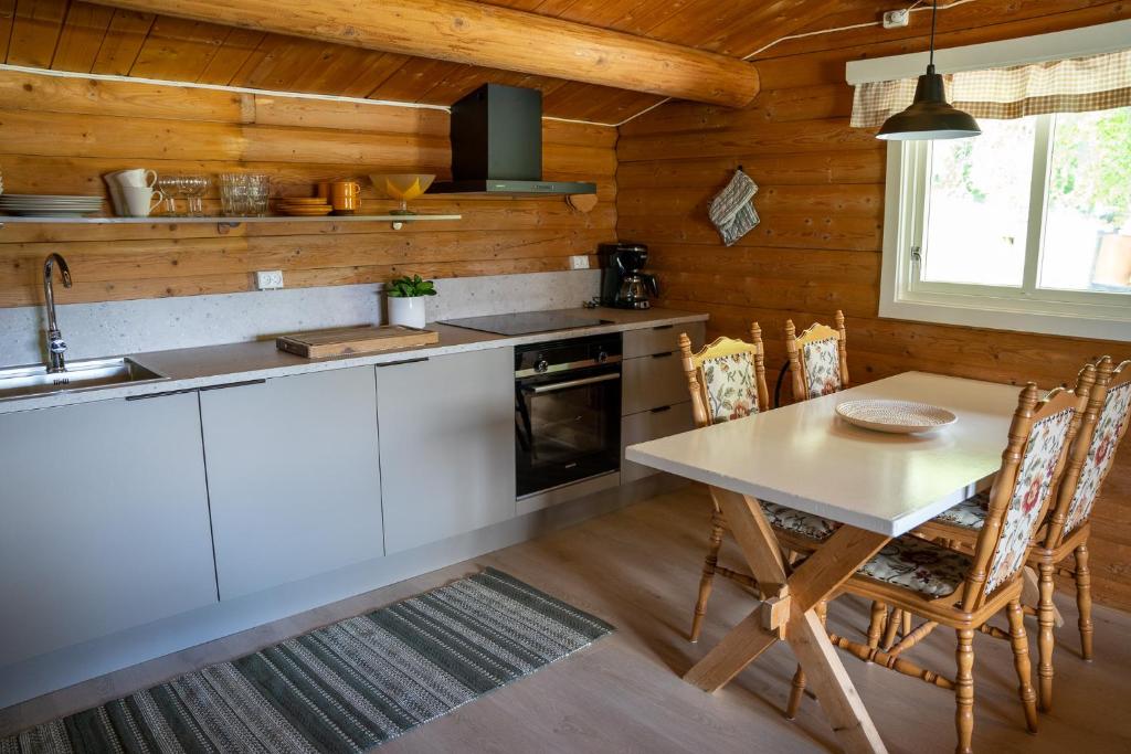 a kitchen with a table and chairs and a sink at Åndalsnes Hytteutleie in Åndalsnes