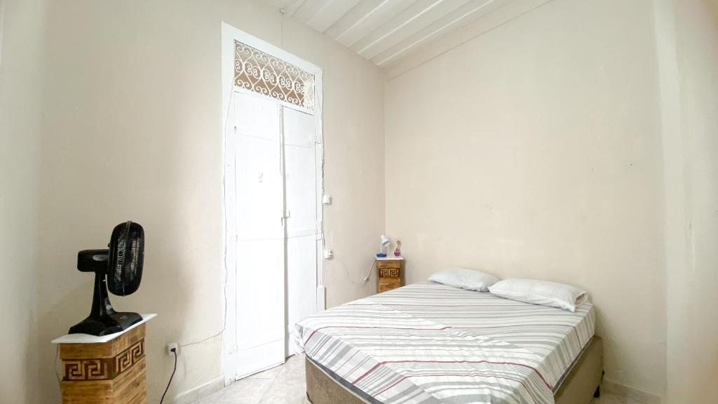 a white bedroom with a bed and a window at Hostel Canto Zen in Salvador