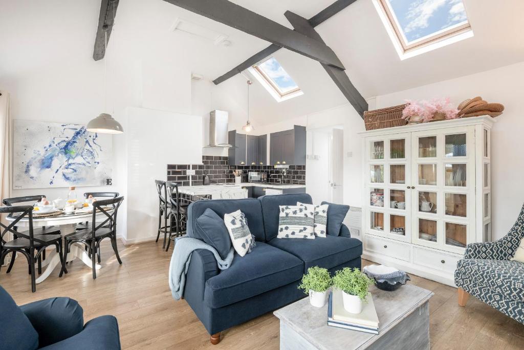 a living room with a blue couch and a table at Fisherman Cottage Llanfaes near Beaumaris in Llanfaes