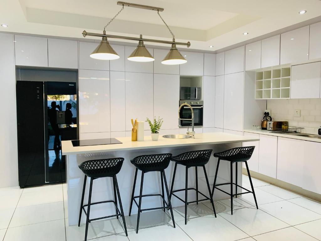 a kitchen with a island with bar stools at Essence Lifestyle Self-Catering Accommodation - Academia in Windhoek