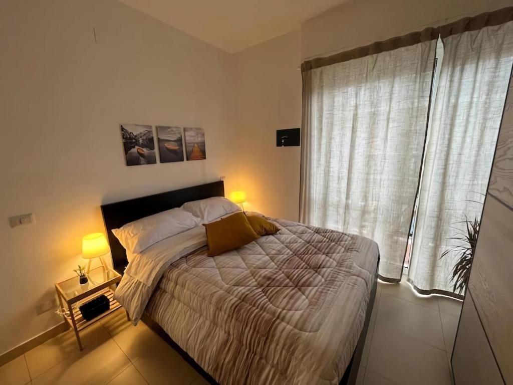 een slaapkamer met een groot bed en een raam bij The Base - Comfort a Milano in Milaan