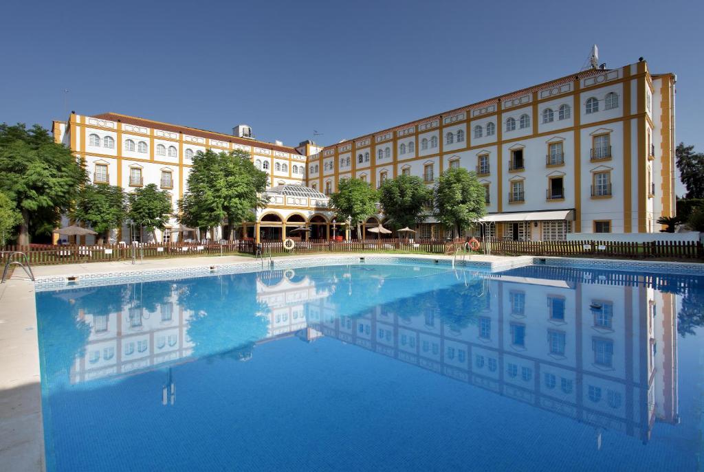サンルカル・ラ・マヨールにあるExe Gran Hotel Solucarの大きな建物の前の大きなプール