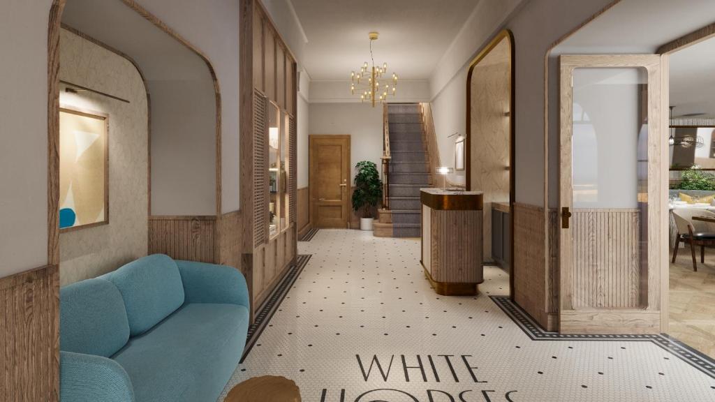 un pasillo con un sofá azul en una habitación en White Horses by Everly Hotels Collection, en Rottingdean