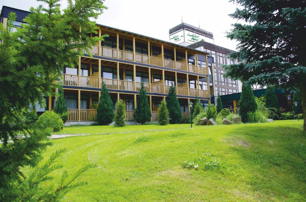ein großes Gebäude mit Rasen davor in der Unterkunft Landhotel Harz in Thale