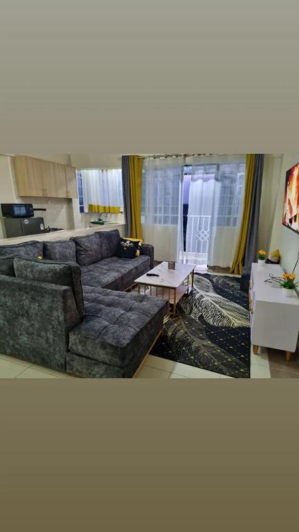 a living room with a couch and a table at Elegant One Bedroom Garden Estate in Nairobi