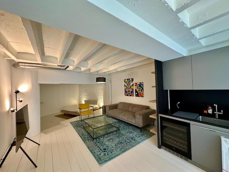 un soggiorno con divano e tavolo di Loft industriel en duplex - The Urban Garage a Losanna