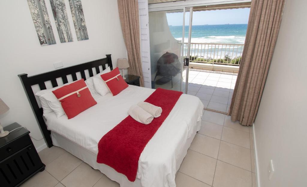Schlafzimmer mit einem Bett und Meerblick in der Unterkunft 6 Bronze Bay Umhlanga Rocks in Durban