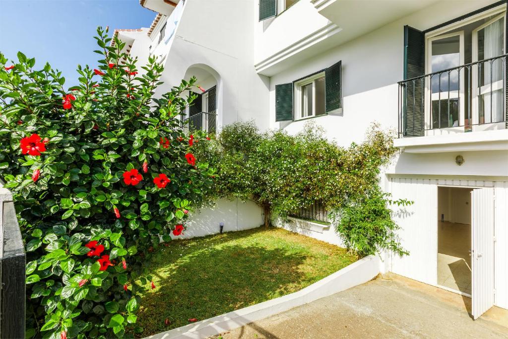 托雷德爾馬爾的住宿－A&N Ribeiro，白色房子的一侧有红色的鲜花