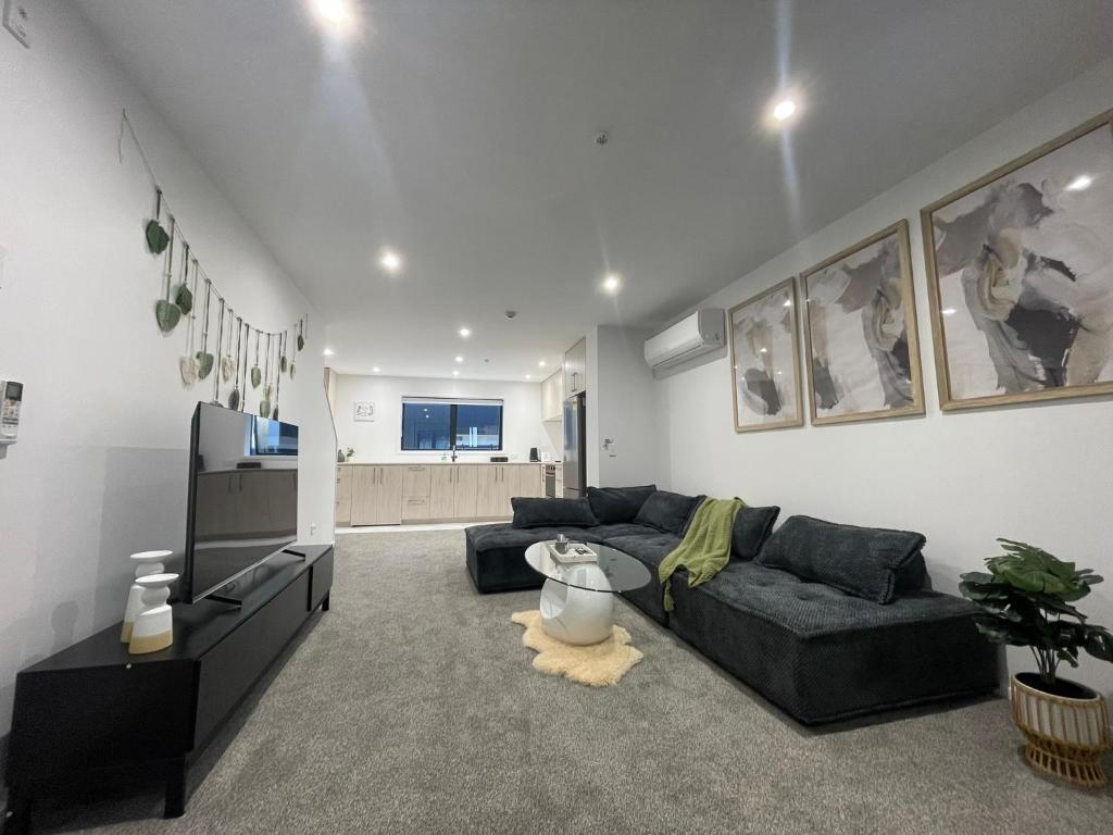 a living room with a couch and a tv at Luxury CBD 2 Bed Near Riverside Market Free Parking! in Christchurch