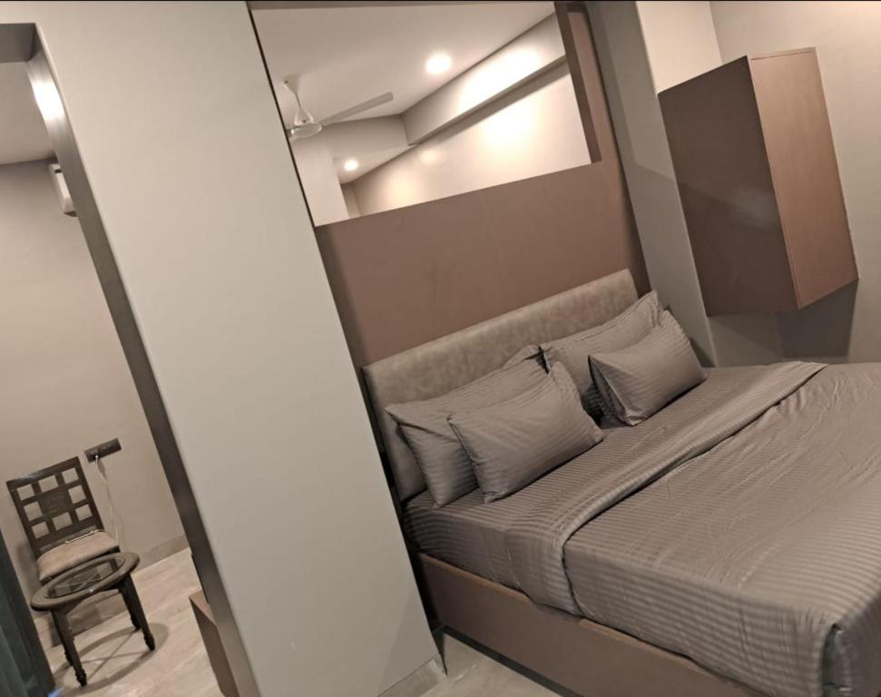 a bedroom with a bed with a mirror and a chair at Sai Celebrations Inn Shirdi in Shirdi