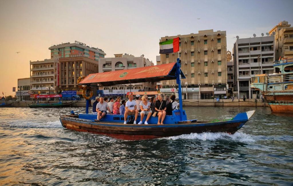 un grupo de personas en un barco en el agua en Honeycomb Capsule Hostel Near Burjuman and Sharaf dg metro, en Dubái