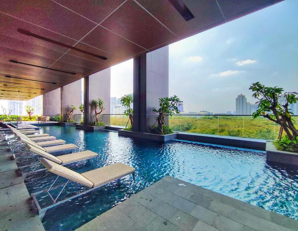 a swimming pool with lounge chairs in a building at BRAND NEW 2BR Apt Menara Jakarta, Jkt Inter Expo in Jakarta