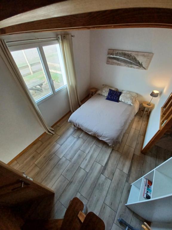 ein kleines Schlafzimmer mit einem Bett und einem Fenster in der Unterkunft Joli maisonnette in Bégaar