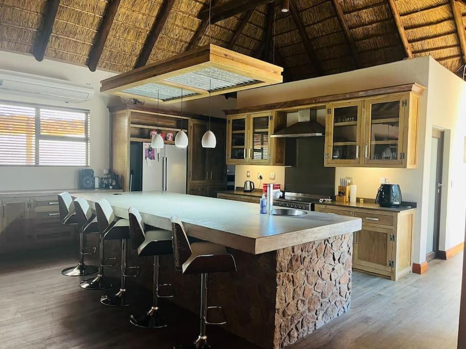 Bush Villa Ditholo 51 في Mmukubyane: مطبخ مع جزيرة كبيرة مع كراسي بار