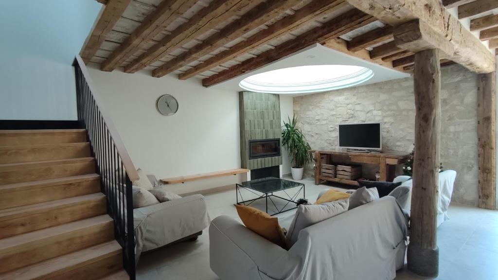 a living room with a couch and a staircase at Casa de Agustín in Valverde del Majano